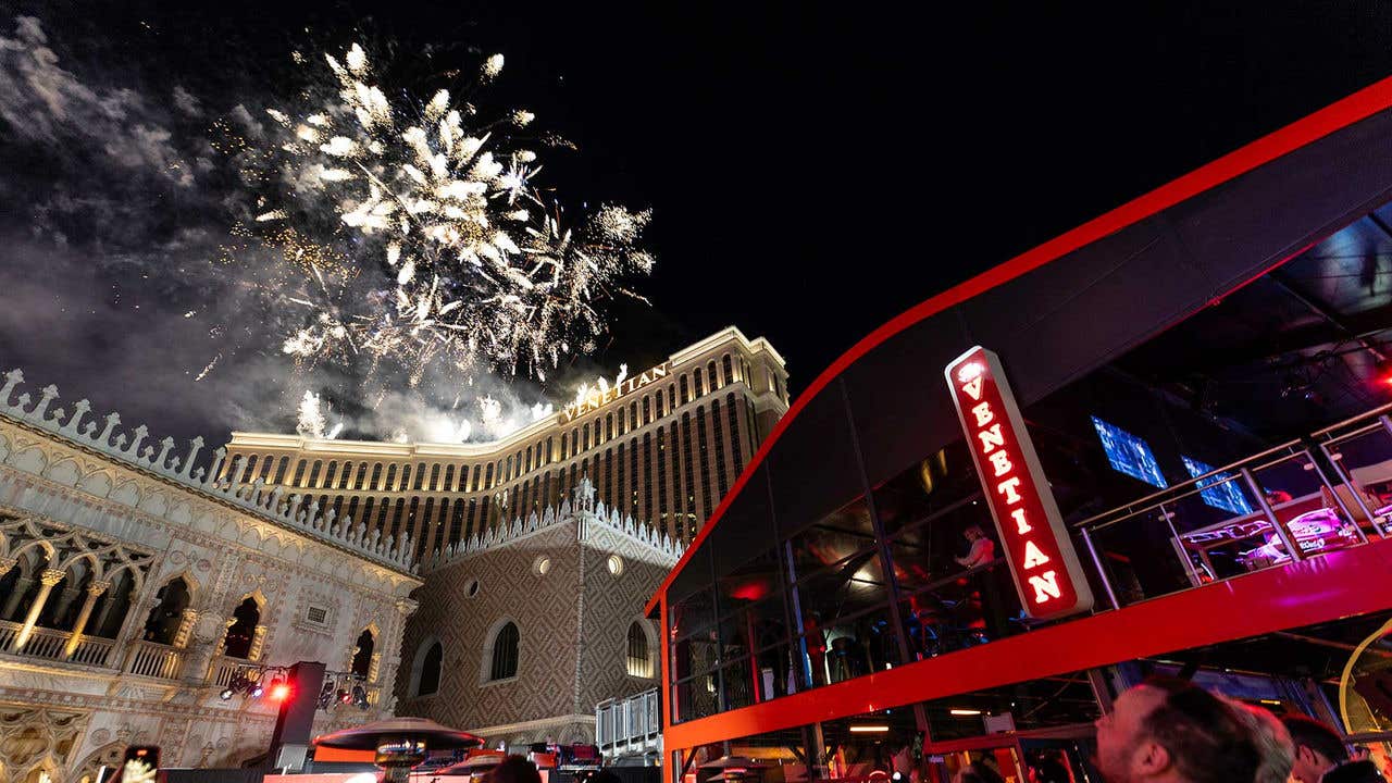 Fireworks going off in the night sky above The Venetian Resort Las Vegas, with the red race viewing platform on the right of the image